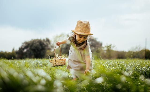 Petite fille qui cueille de l'herbe