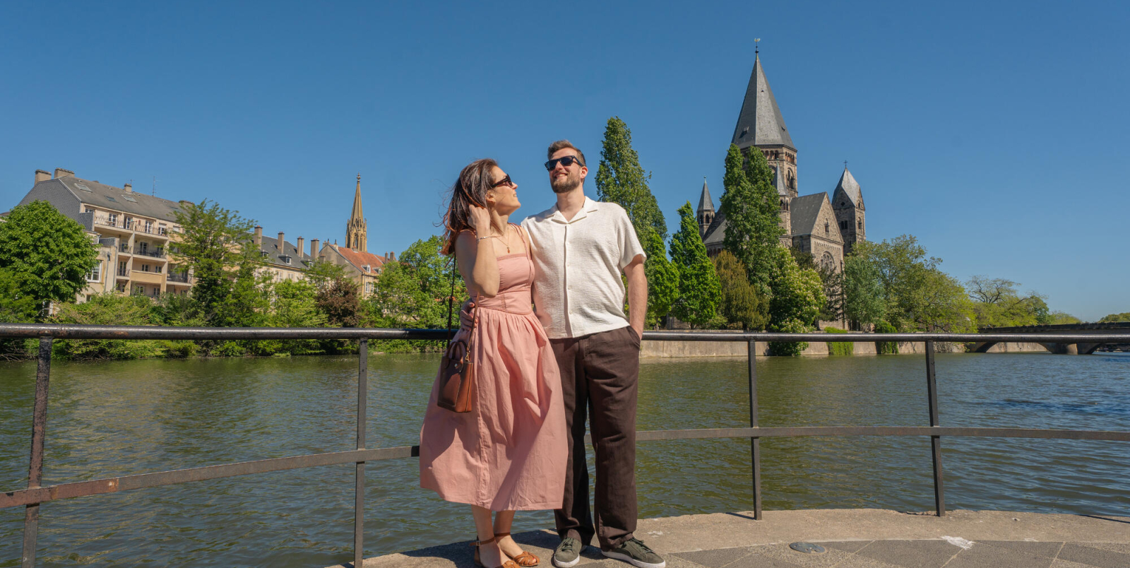 une femme et un homme debout devant un plan d’eau